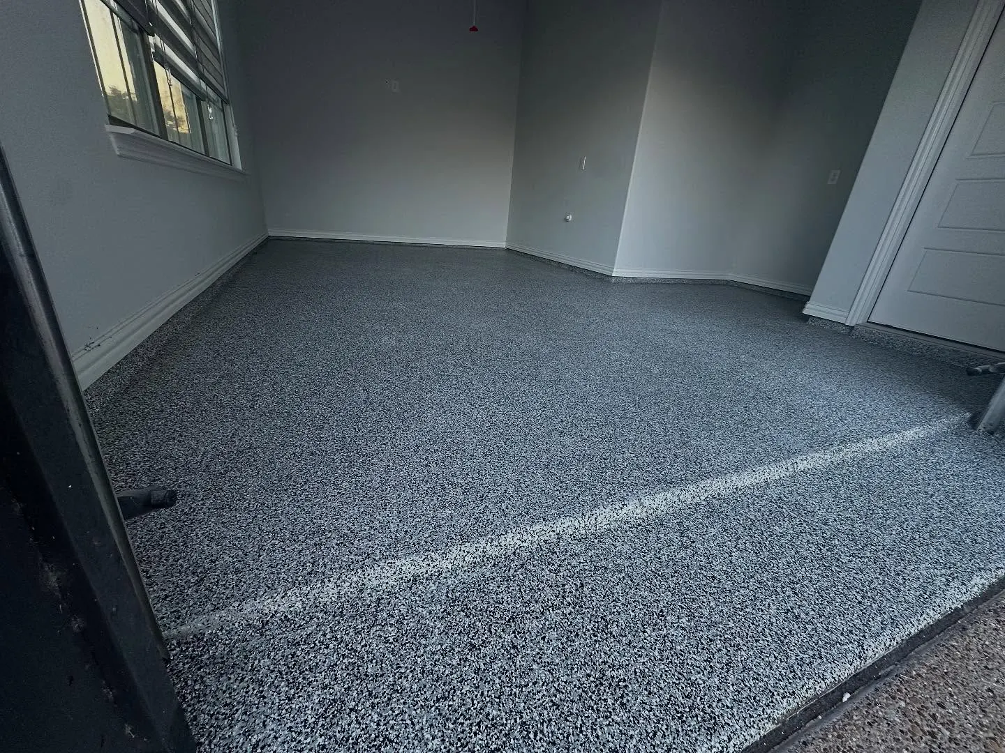 Finished black and gray flake polyaspartic garage floor in Fort Worth, TX, a Flooring Contractor Arlington project